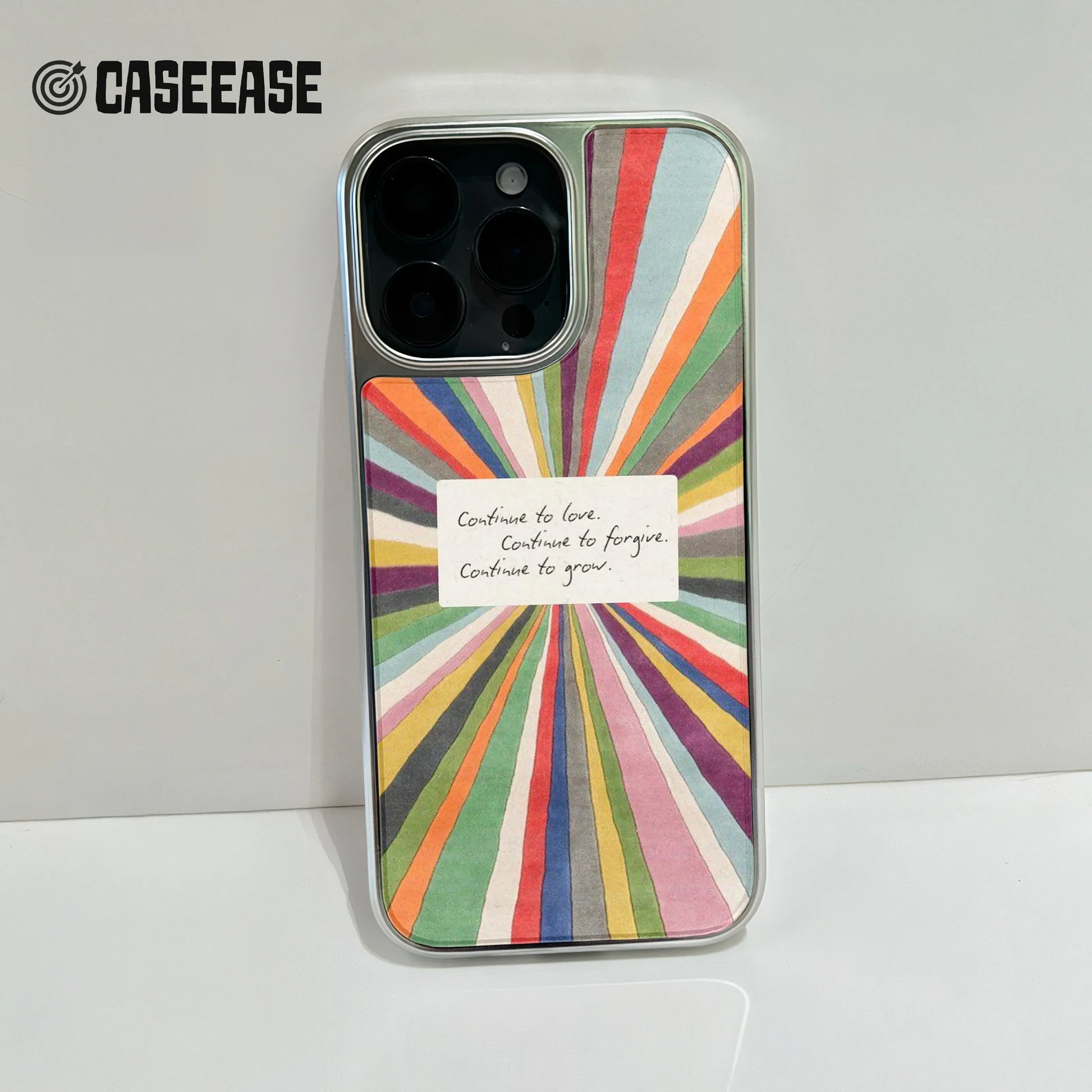 Colorful sunburst illustration with an inspirational handwritten note in the center reading: "Continue to love. Continue to forgive. Continue to grow."